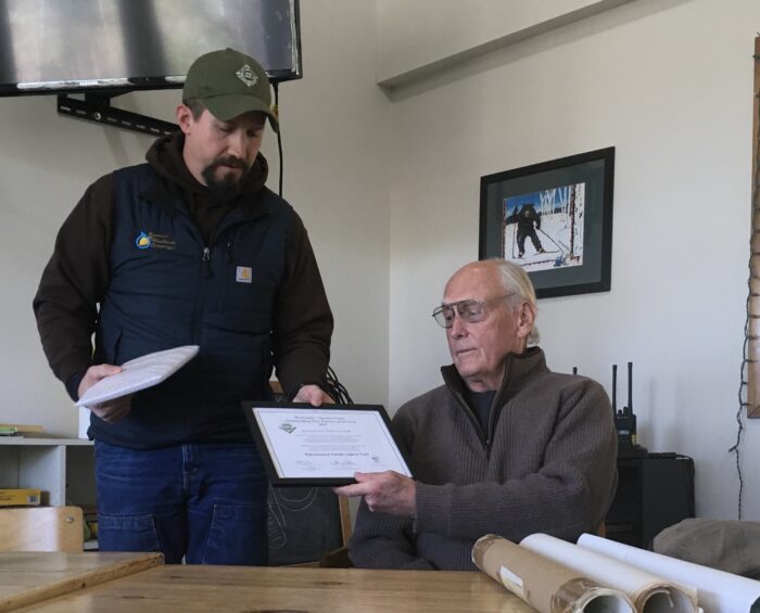 Matt Carothers presents Chuck Kuhnmuench with award for District 5 Outstanding Tree Farmer Award.